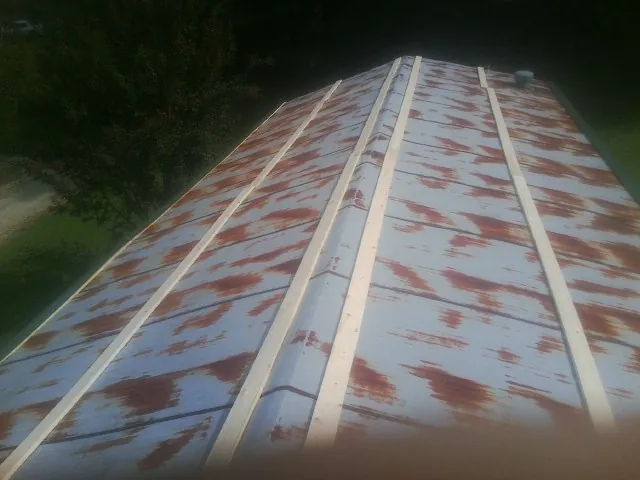 Rusted metal roof panels with new wood purlins before replacement — Storm Damage Roof Repair in Oak Island by Roofing Brothers