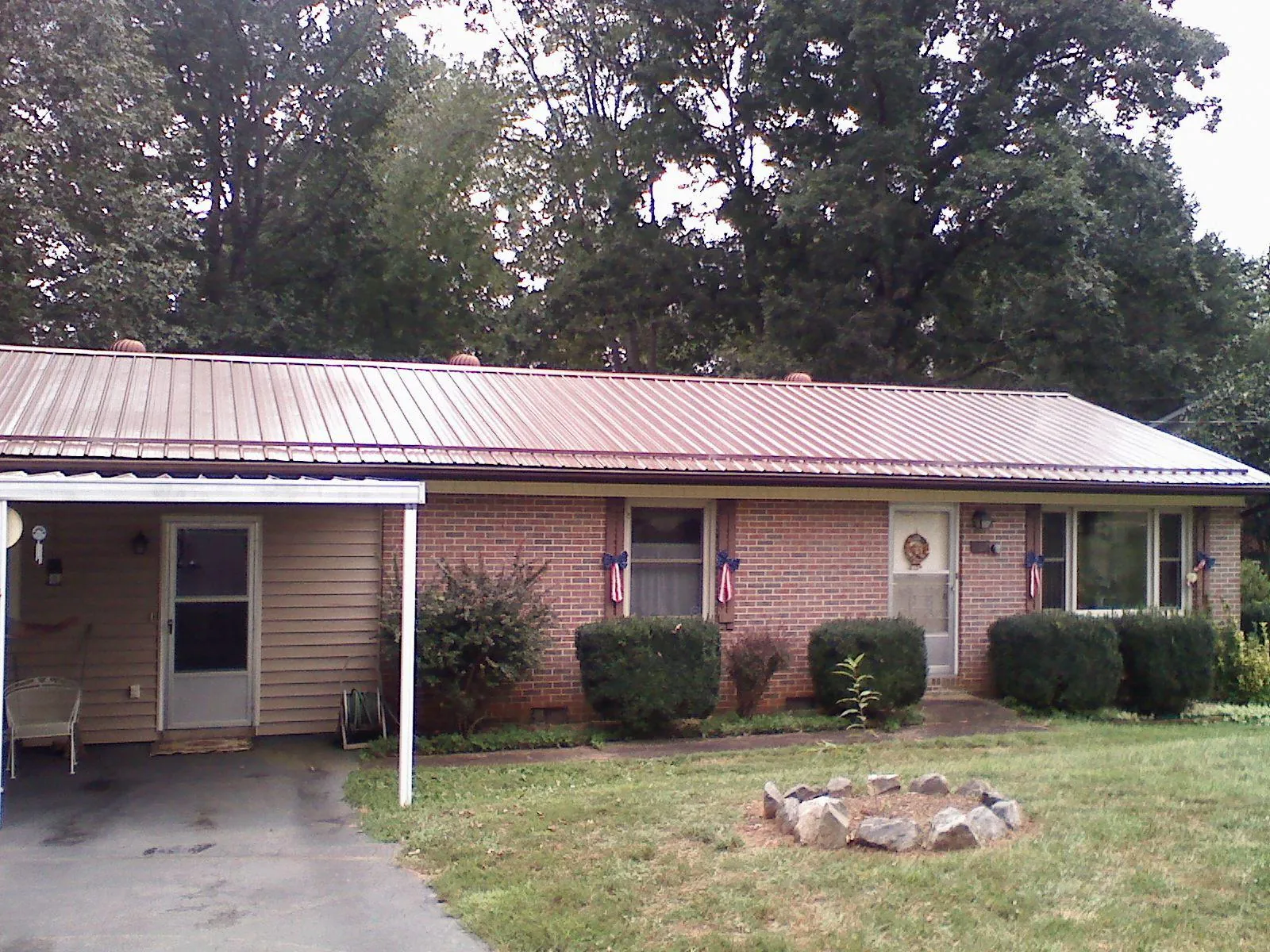 Bronze metal roof and carport on a brick ranch home — Roof Repair work by our crew in Oak Island